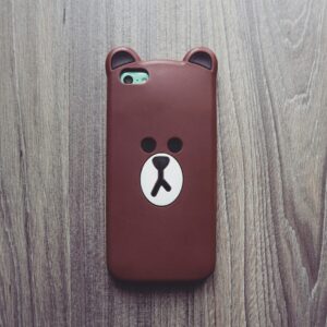 INICIO Cute bear phone case resting on a rustic wooden table, ideal for tech and lifestyle themes.